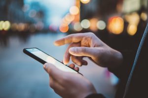 action-fraud Person using touchscreen smart phone